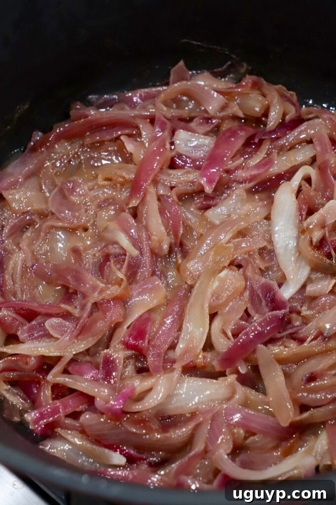 sliced onions caramelizing in pot on stove