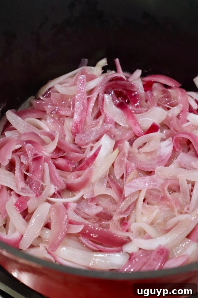 sliced onions cooking in pot on stove