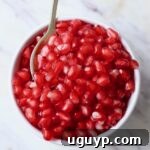 Pomegranate arils in a bowl with a spoon