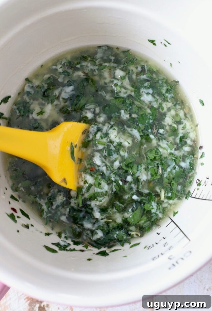 Melted butter combined with herbs and seasonings in a bowl, ready for application.