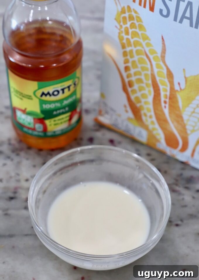 A small glass bowl containing a cornstarch slurry, a mixture of cornstarch and apple juice.