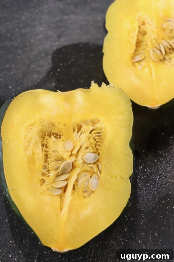 a cooked acorn squash, now cut in half, displaying its tender flesh on a cutting board