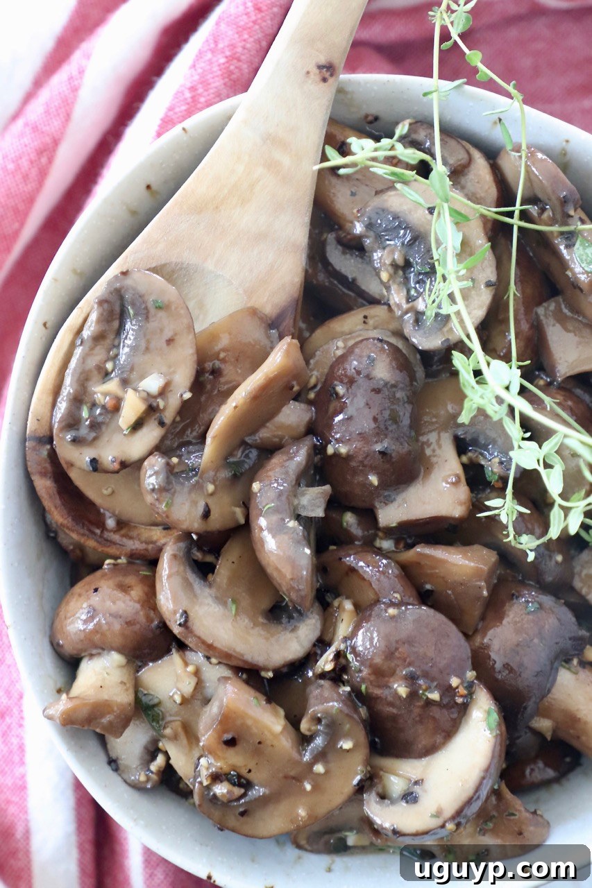 Sauteed mushrooms in a bowl with a wooden spoon