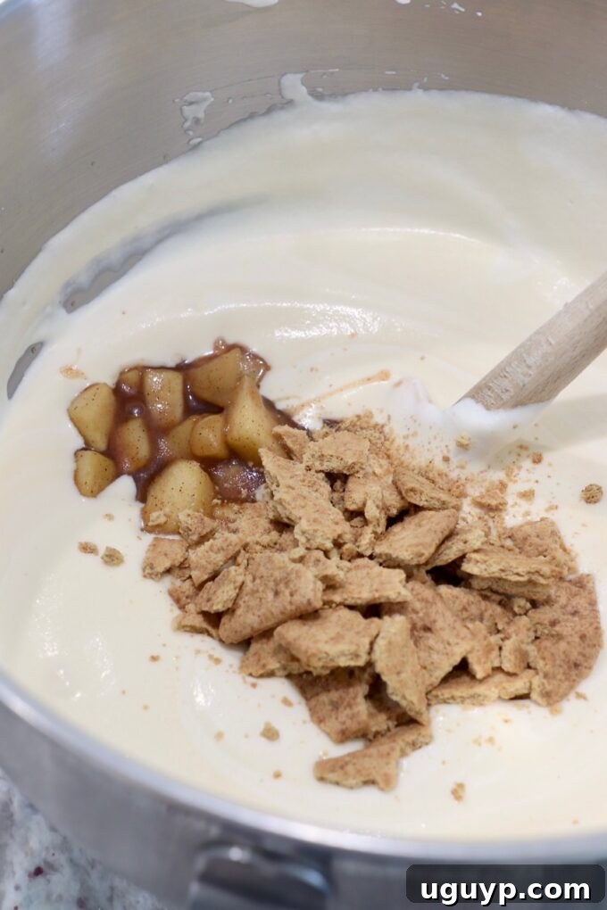 Chopped graham crackers and apple pie filling gently folded into the airy whipped cream mixture in a large bowl.