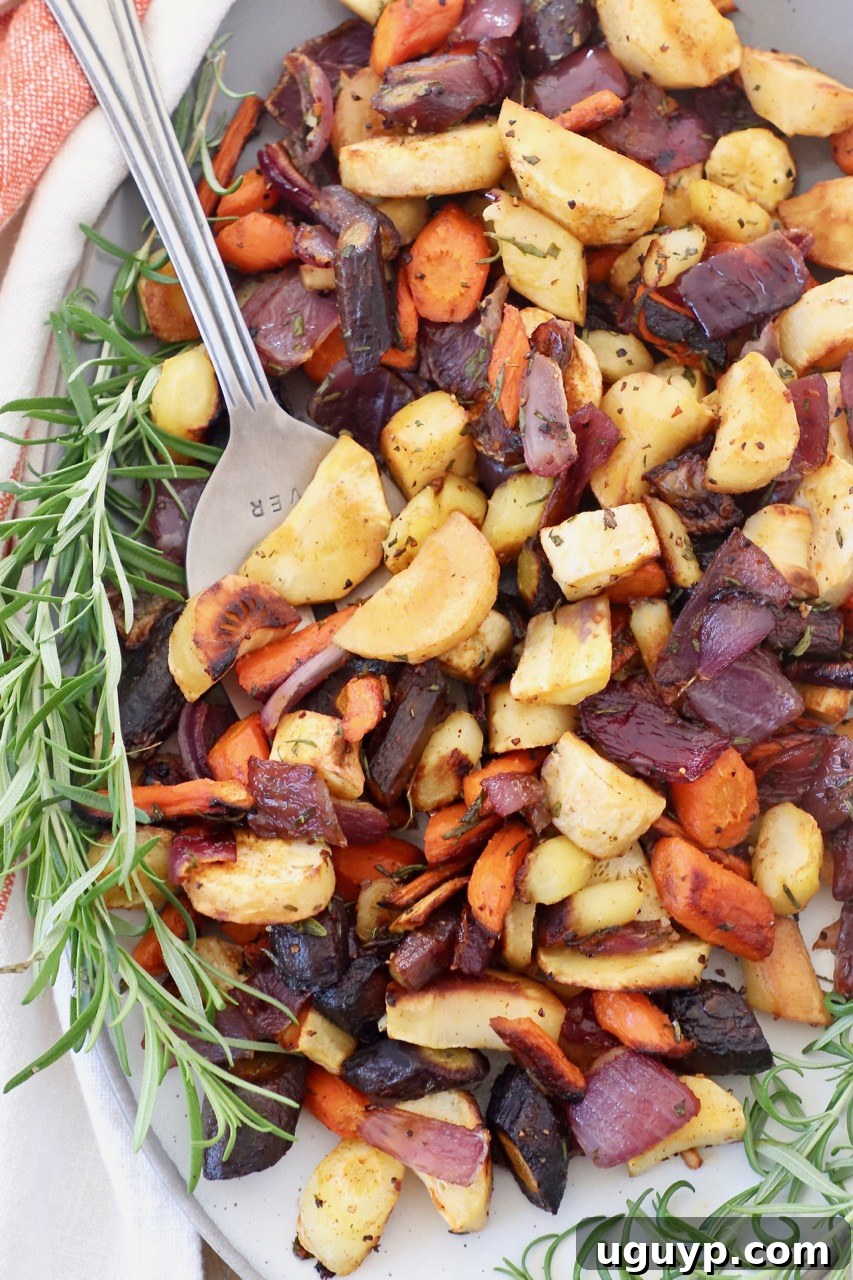 Roasted vegetables on plate with serving fork and fresh rosemary sprigs