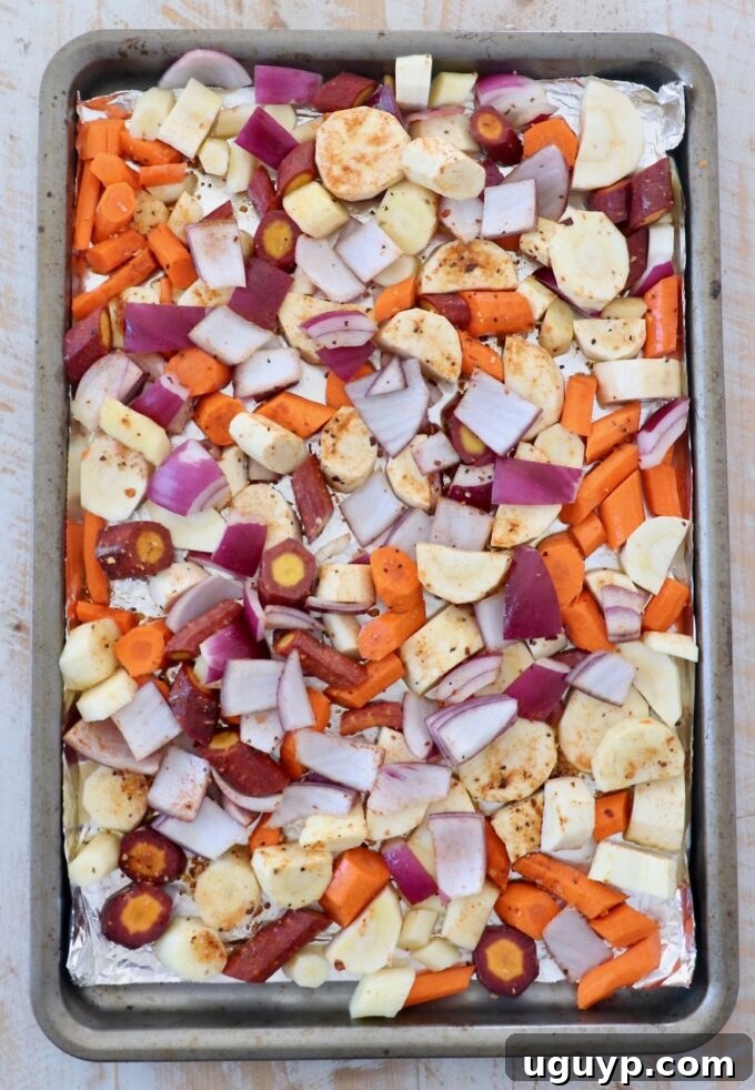Uncooked diced vegetables on parchment lined baking sheet