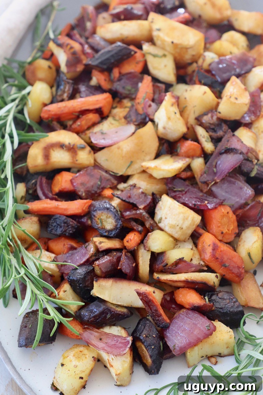 Roasted cubed vegetables on plate with fresh sprigs of rosemary