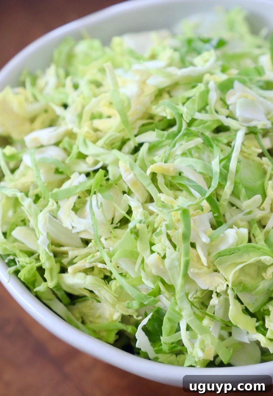 A crisp white bowl filled with freshly shredded Brussels sprouts, ready for culinary adventure.