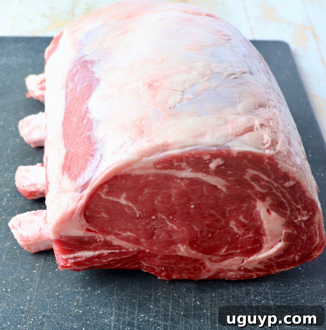 uncooked bone in prime rib on cutting board