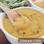 acorn squash soup in bowl with wooden spoon