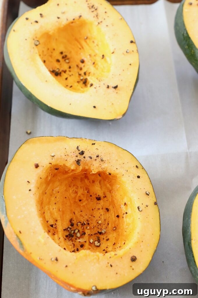acorn squash cut in half on baking sheet