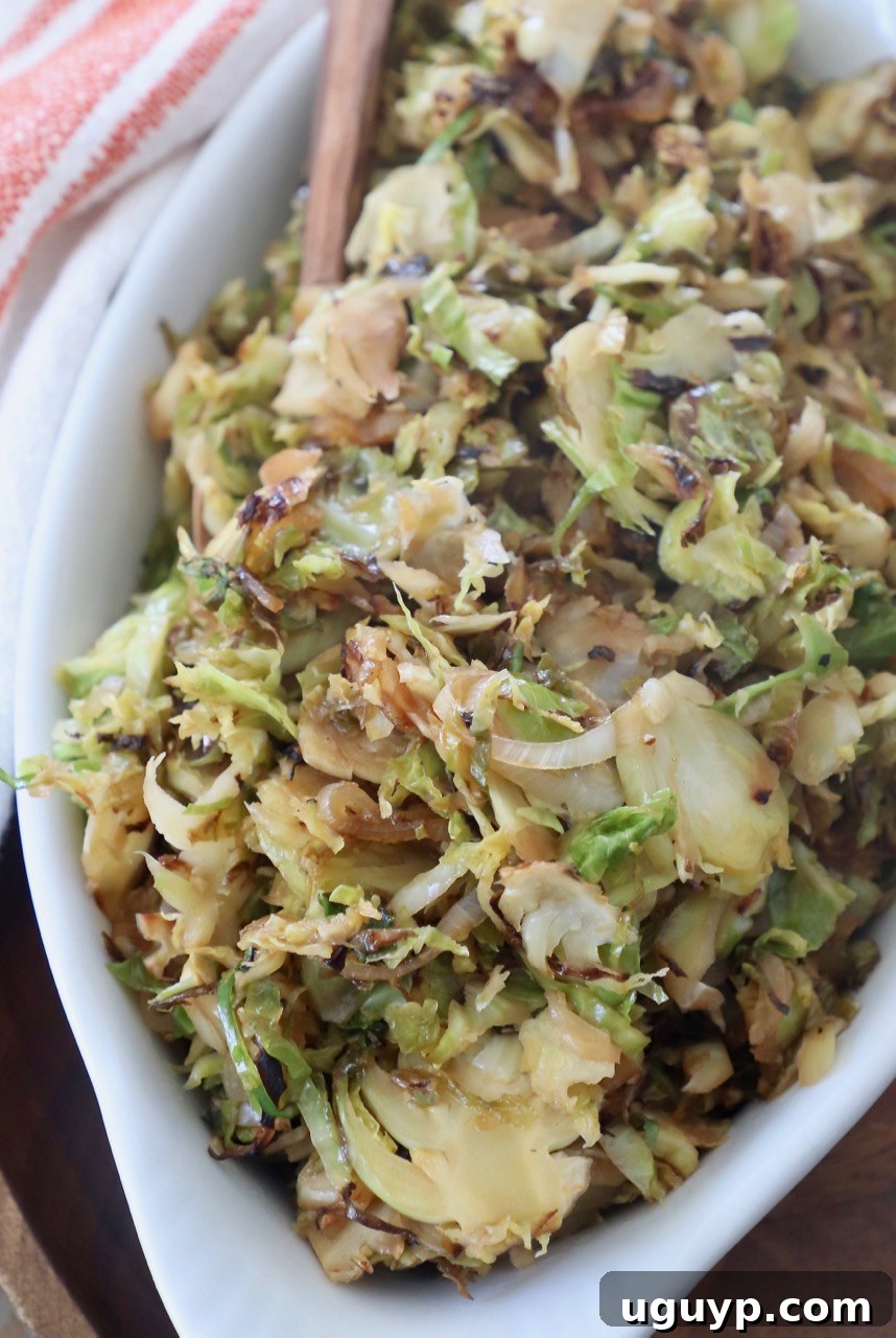 sauteed shredded brussels sprouts in white serving dish with fork