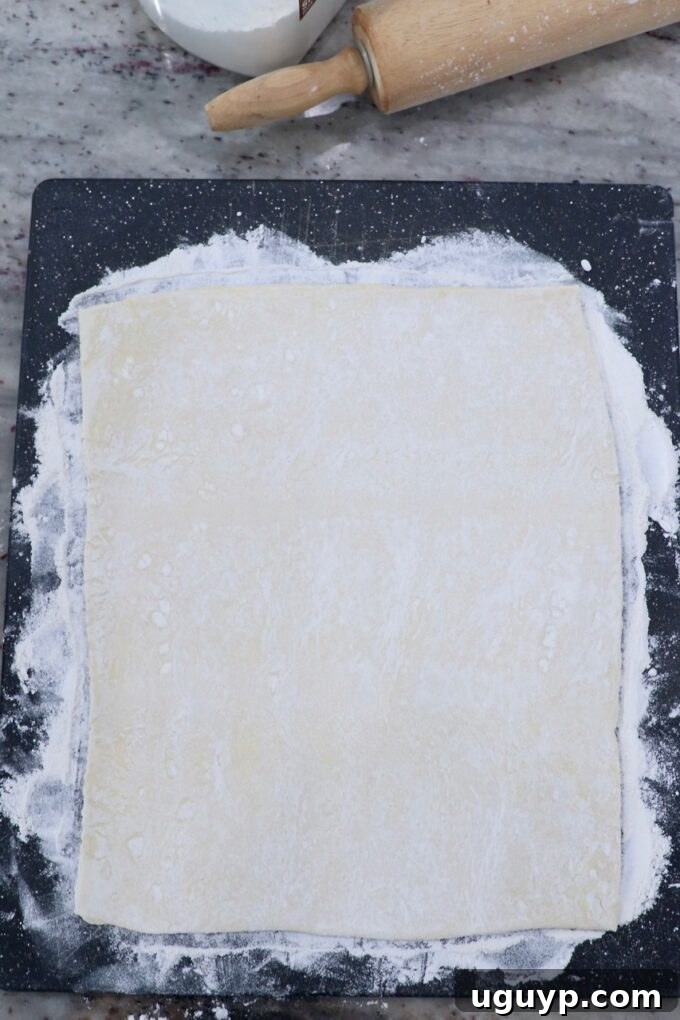 sheet of puff pastry dough rolled out on cutting board