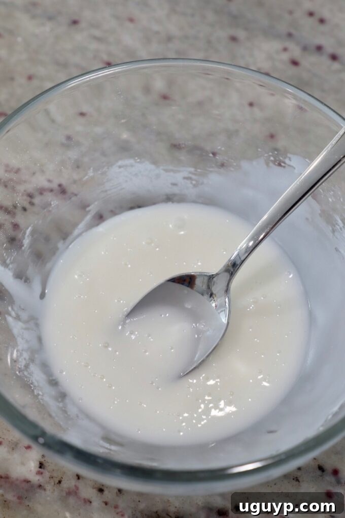 powdered sugar icing in glass bowl with spoon