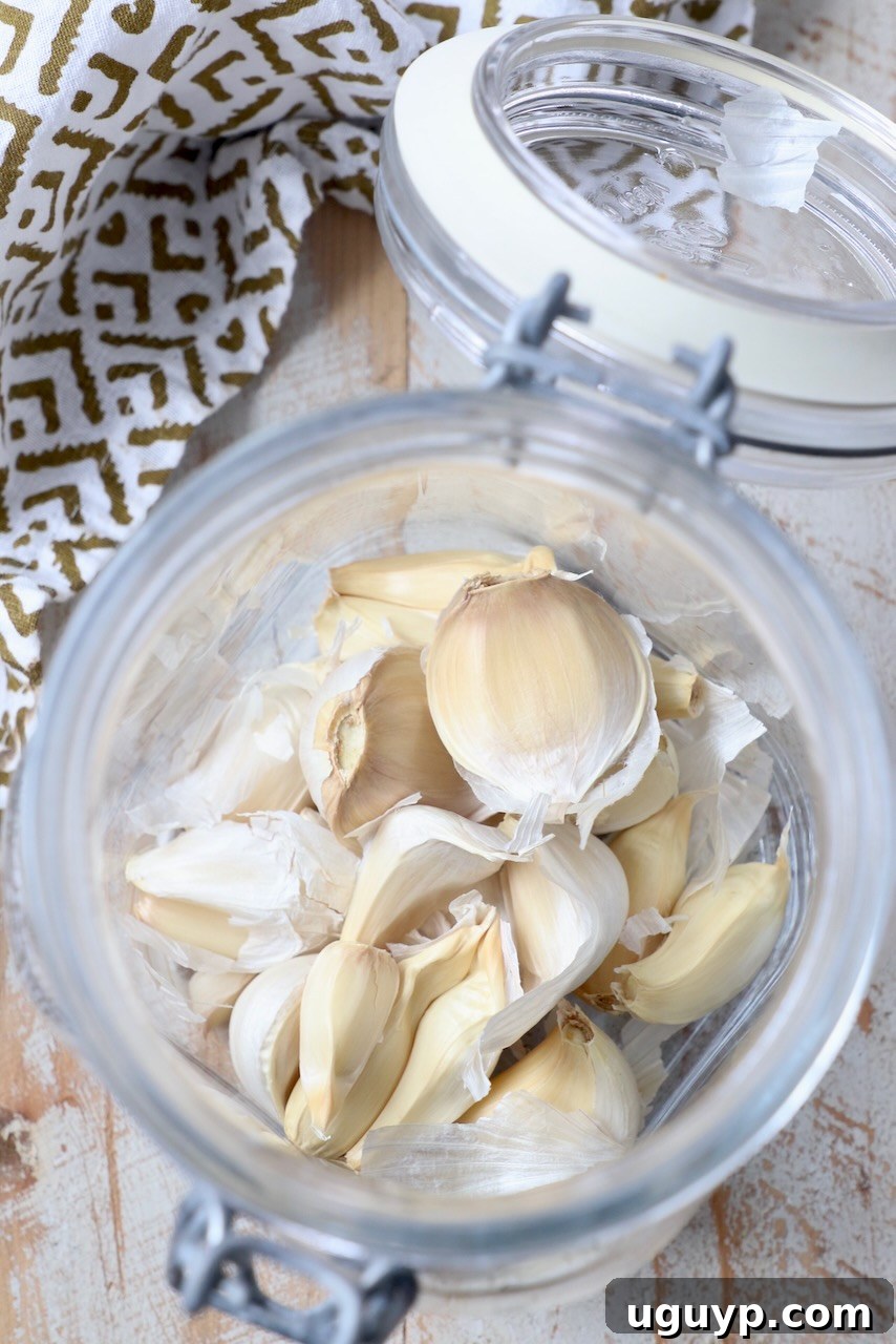 Peeled garlic cloves in a glass jar, ready for use