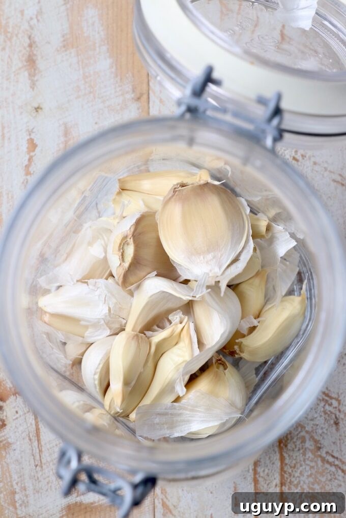 Unpeeled garlic cloves inside a glass jar with the lid on