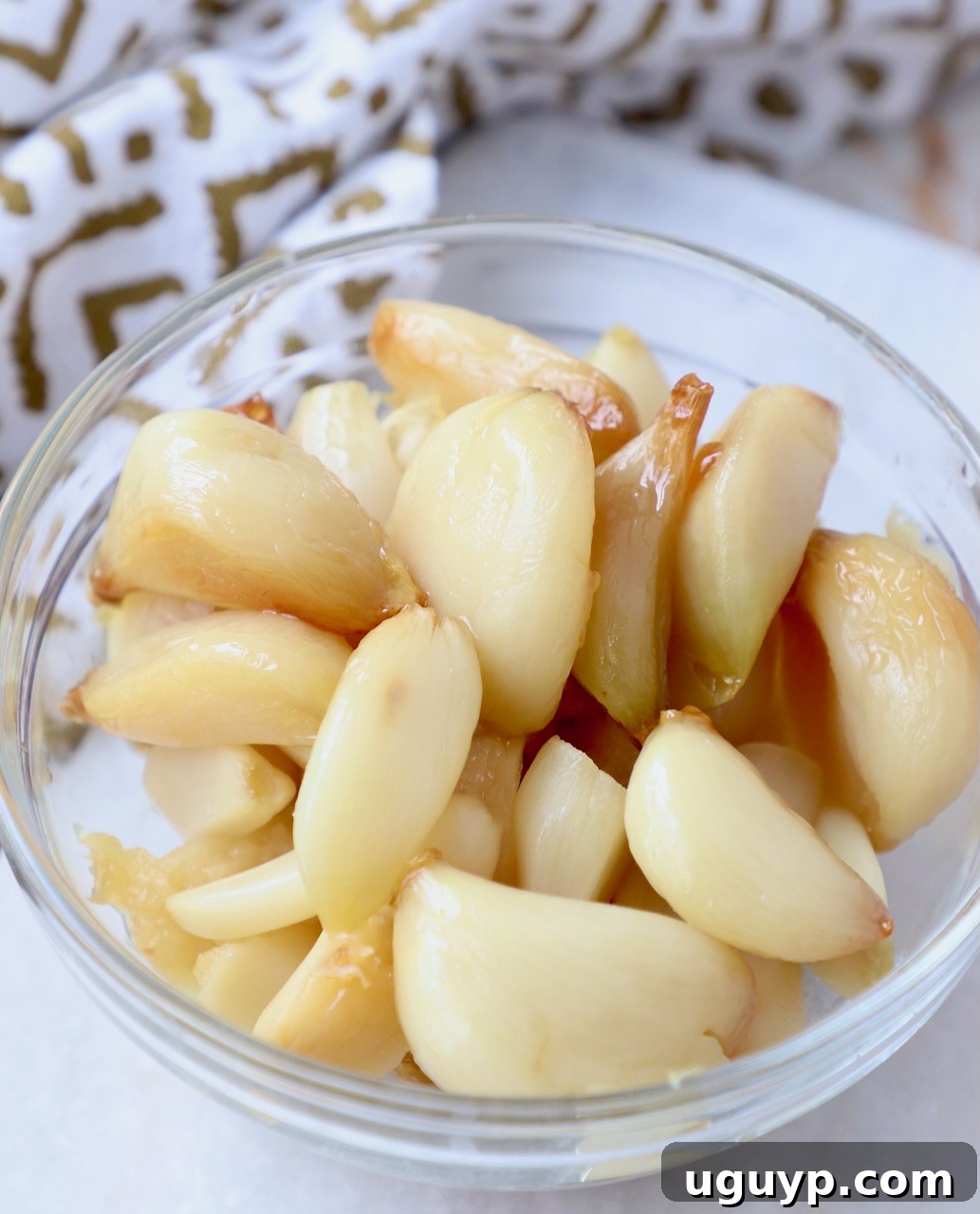 A bowl of rich, golden roasted garlic, ready for culinary use.