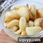 Roasted garlic cloves in a small glass bowl, ready to be used in recipes.