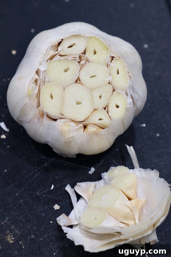 Garlic head with the top portion neatly sliced off, exposing the cloves.