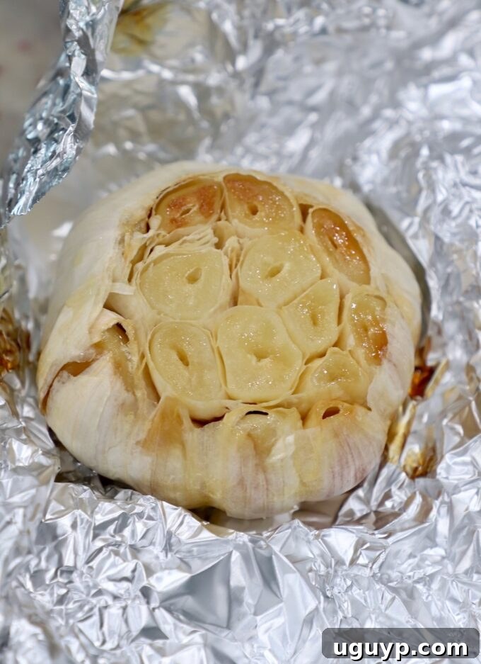 Roasted head of garlic, perfectly wrapped in a piece of foil, ready for the oven.