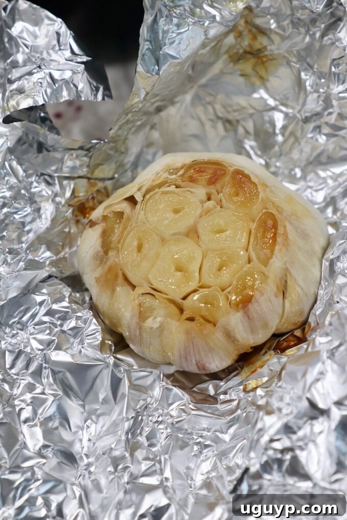 Beautifully roasted head of garlic, tender and golden, removed from foil.