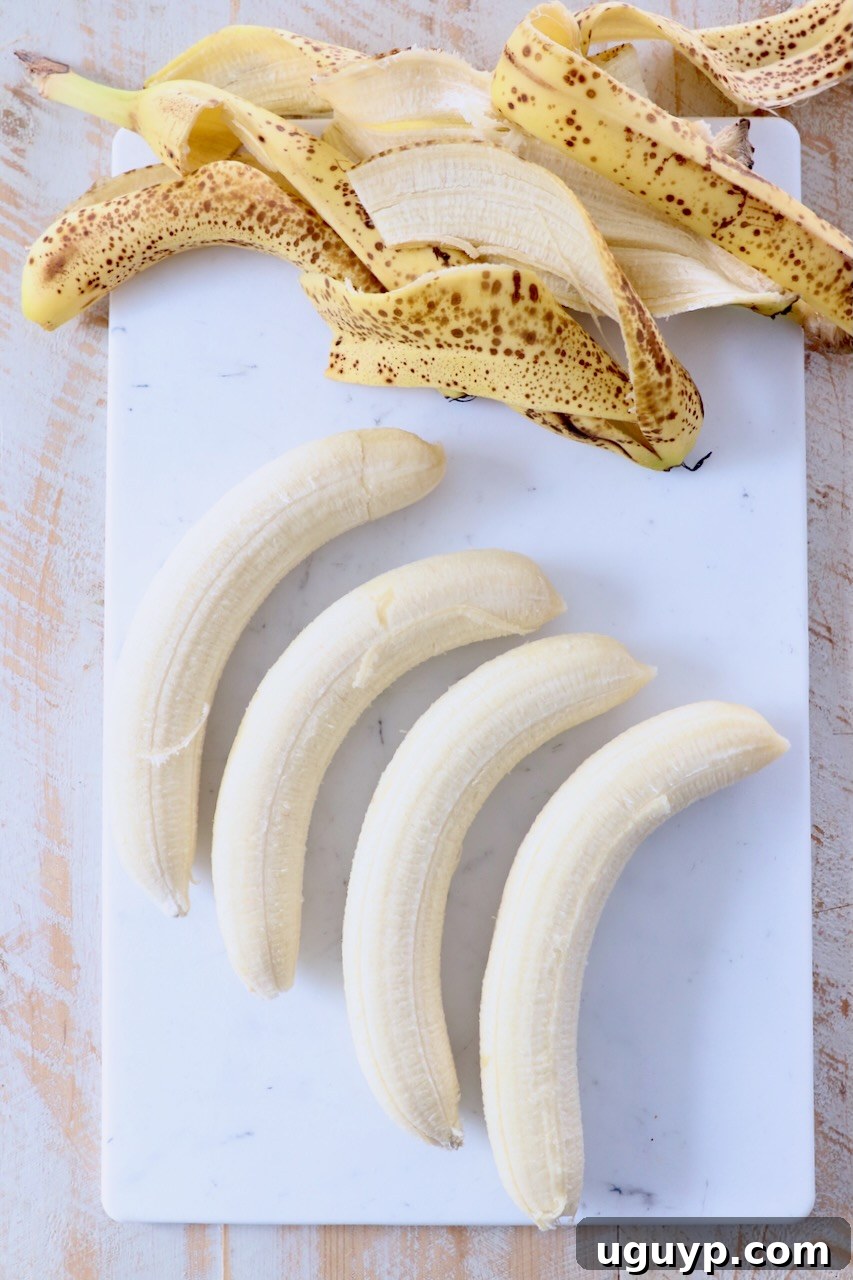 Peeled bananas on a cutting board, ready for freezing.