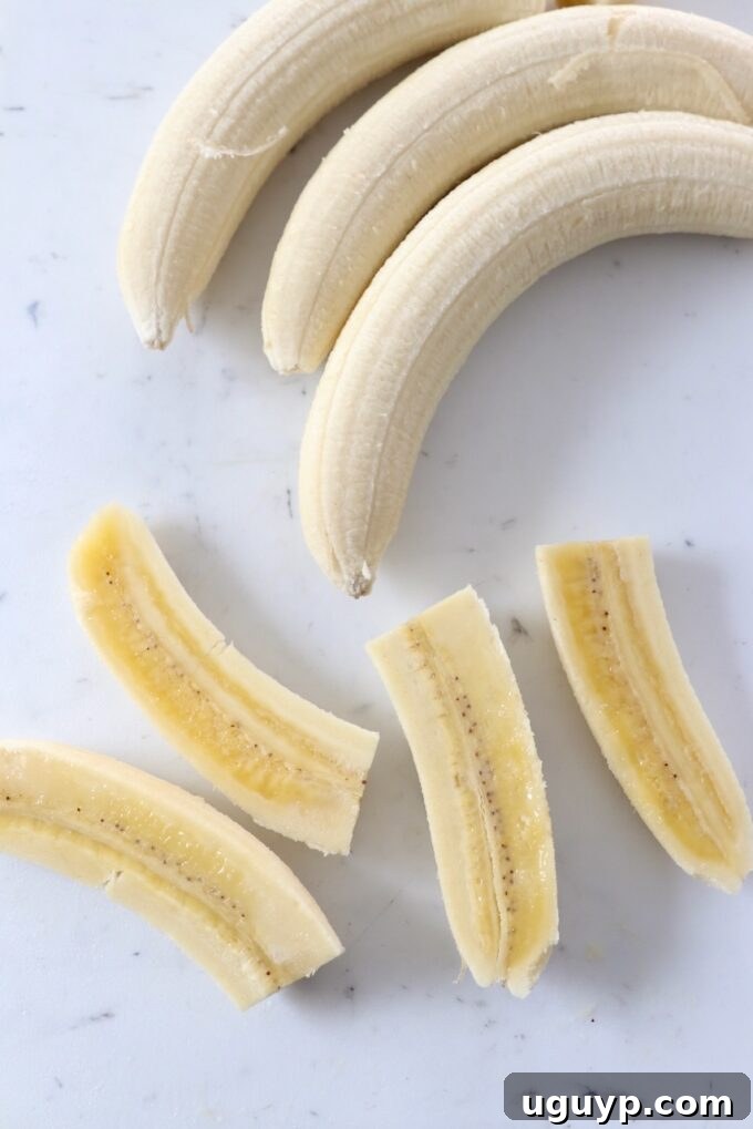 Peeled bananas on cutting board, some sliced into quarters for various uses.