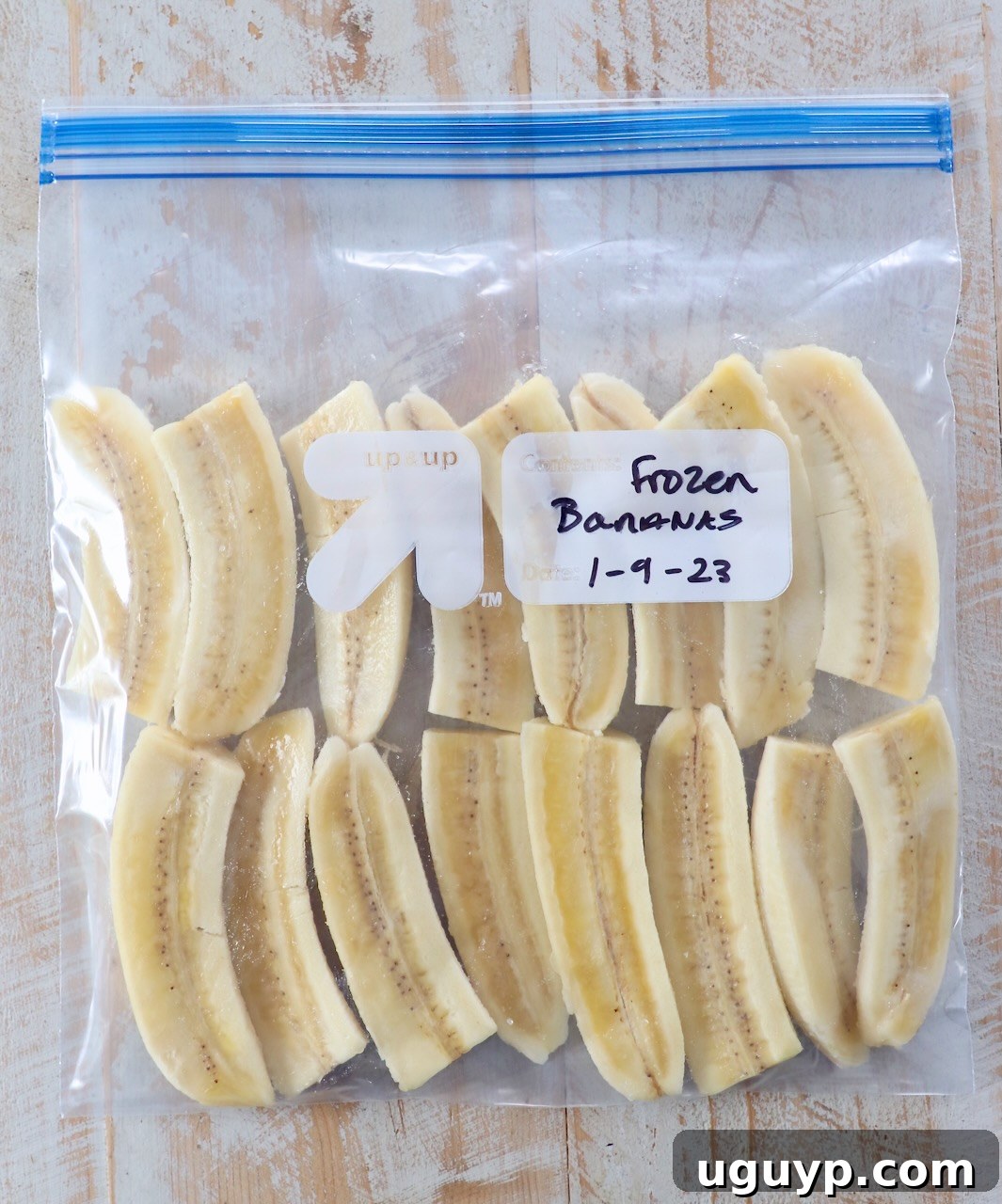 Close-up of frozen banana slices neatly packed in a clear plastic freezer bag.