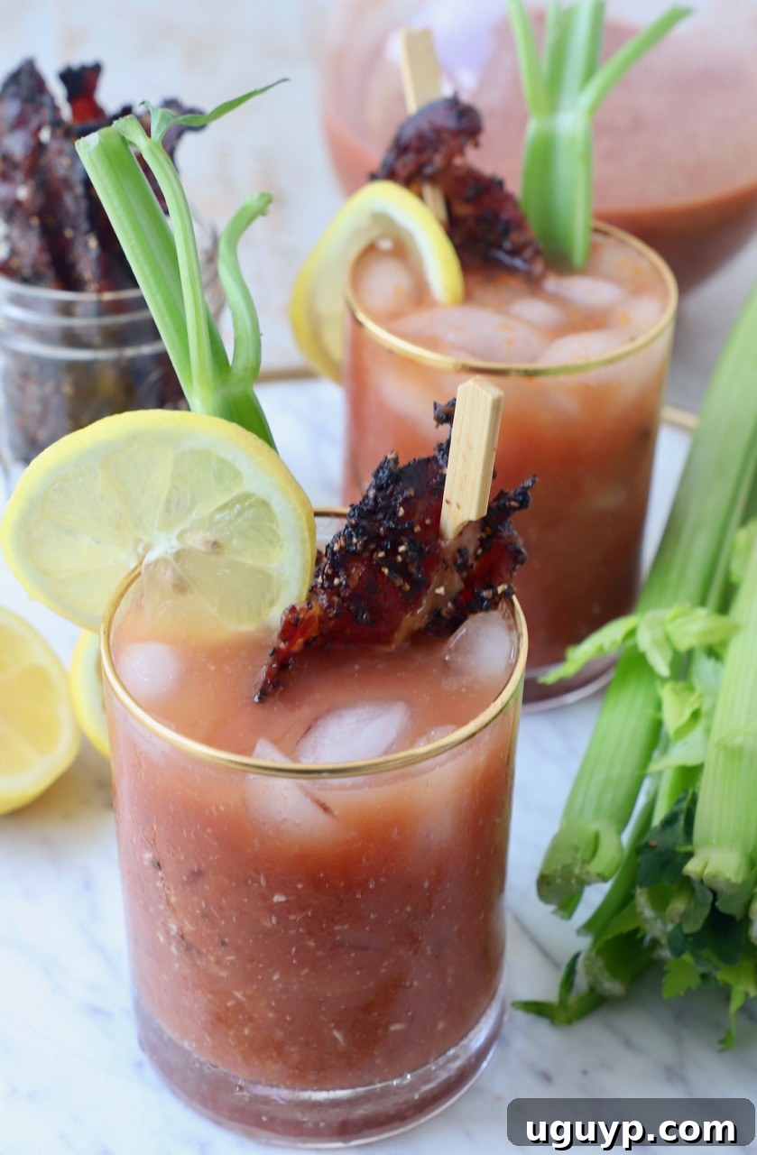 Several Bloody Marys in glasses, garnished with celery sticks, lemon slices, and bacon