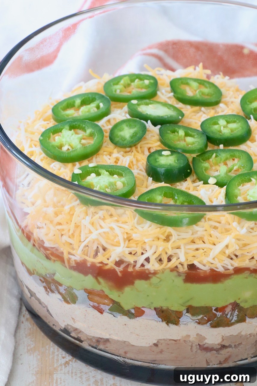 Seven Layer Dip in a beautiful glass trifle bowl, ready to be served at a party