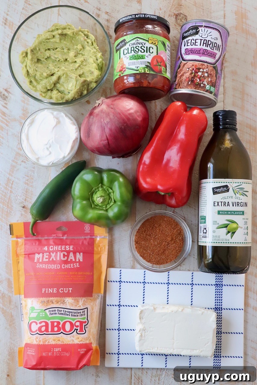 Assortment of fresh ingredients for seven layer dip laid out on a wooden board