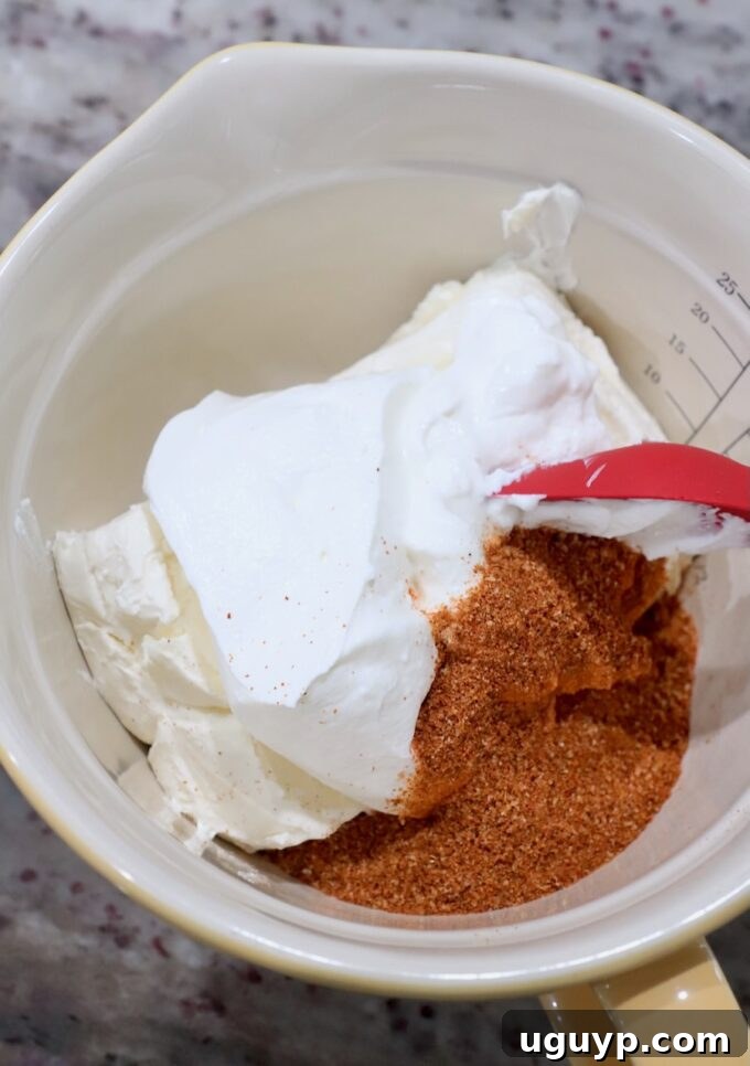 Cream cheese, sour cream, and fajita seasoning mixed in a bowl