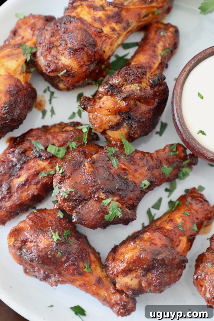 Crispy, cooked chicken wings generously tossed in buffalo sauce, presented on a plate, ready to be enjoyed.