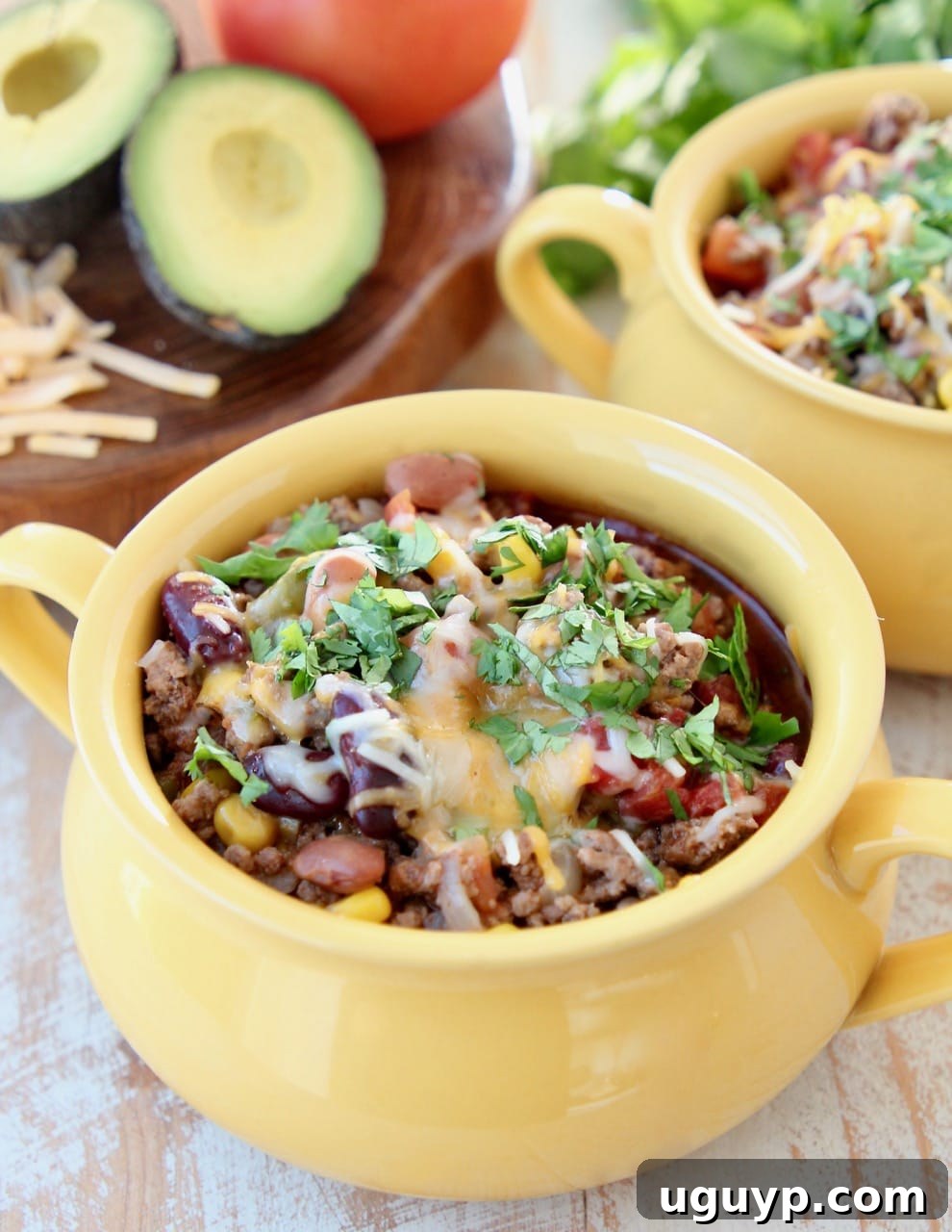 A vibrant bowl of Slow Cooker Taco Soup, generously topped with shredded cheddar cheese and fresh cilantro, ready to be enjoyed.