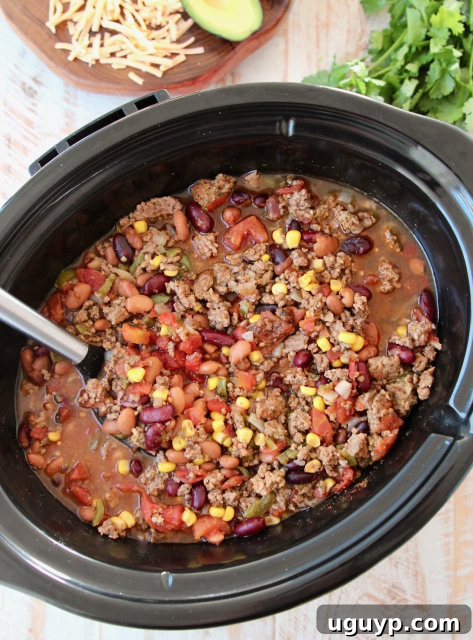 A large pot of Slow Cooker Taco Soup, rich with corn, various beans, diced tomatoes, and ground beef, ready to be served.