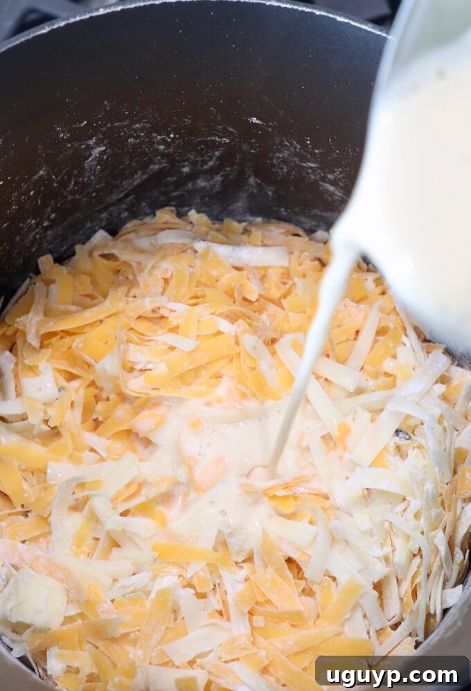 milk being poured into sauce pan of shredded cheese