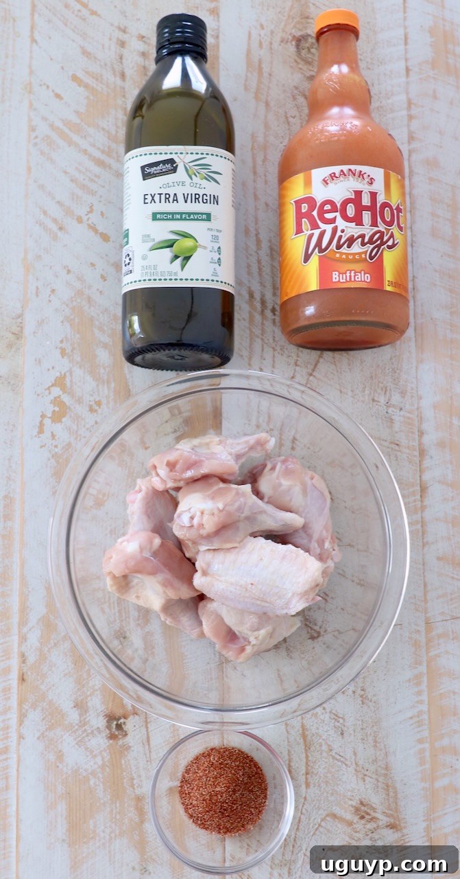 A vibrant display of fresh ingredients for buffalo chicken wings, neatly arranged on a rustic wooden board.