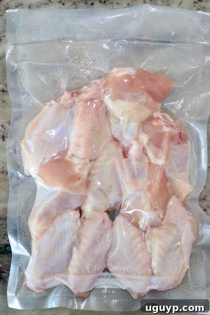 Chicken wings seasoned and vacuum-sealed in a clear bag, ready for sous vide cooking.