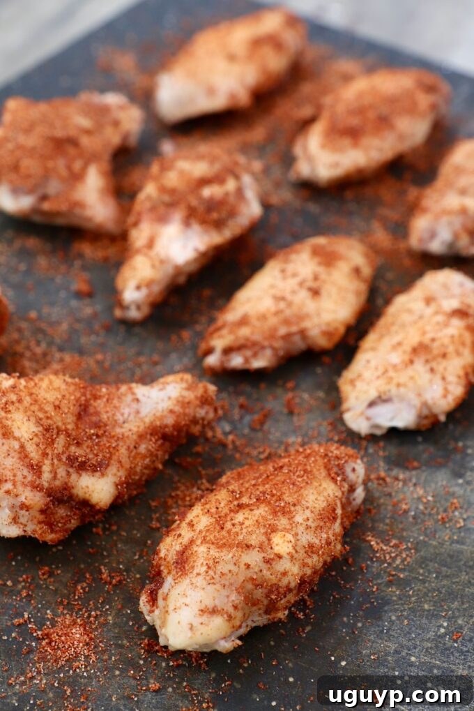 Crispy chicken wings, beautifully seasoned, arranged on a cutting board, ready for serving or saucing.