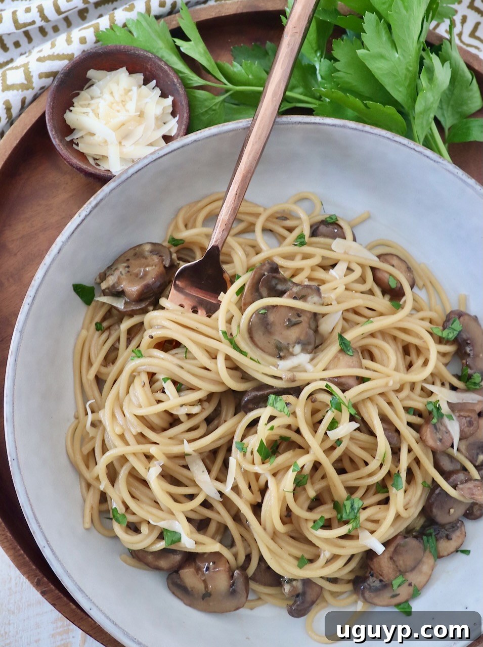 A bowl of hot mushroom pasta with a fork, ready to be enjoyed.