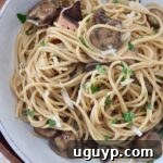 Mushroom pasta in a bowl with a fork, ready to be served.