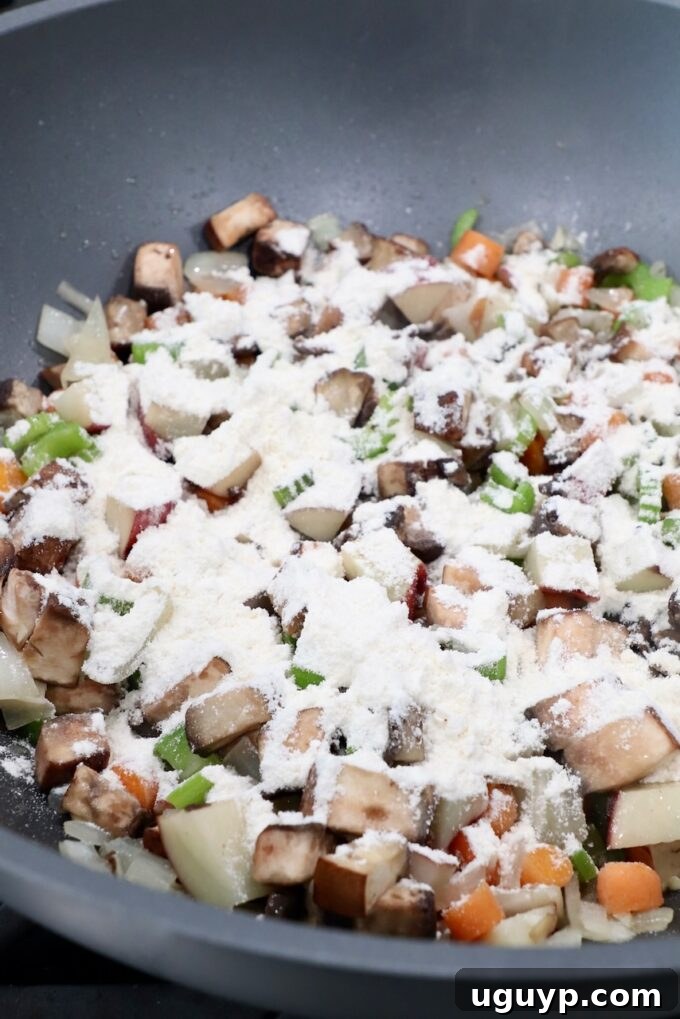 flour sprinkled over diced vegetables in pan