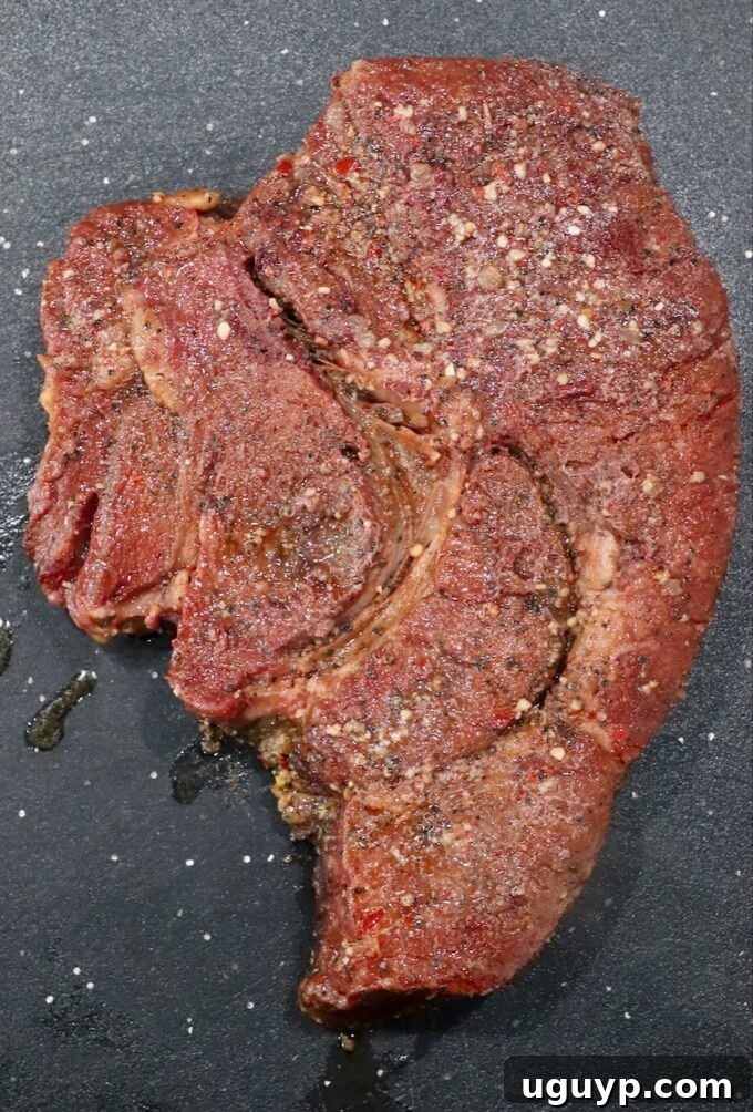 Perfectly smoked chuck roast resting on a cutting board, having achieved deep color and tenderness.