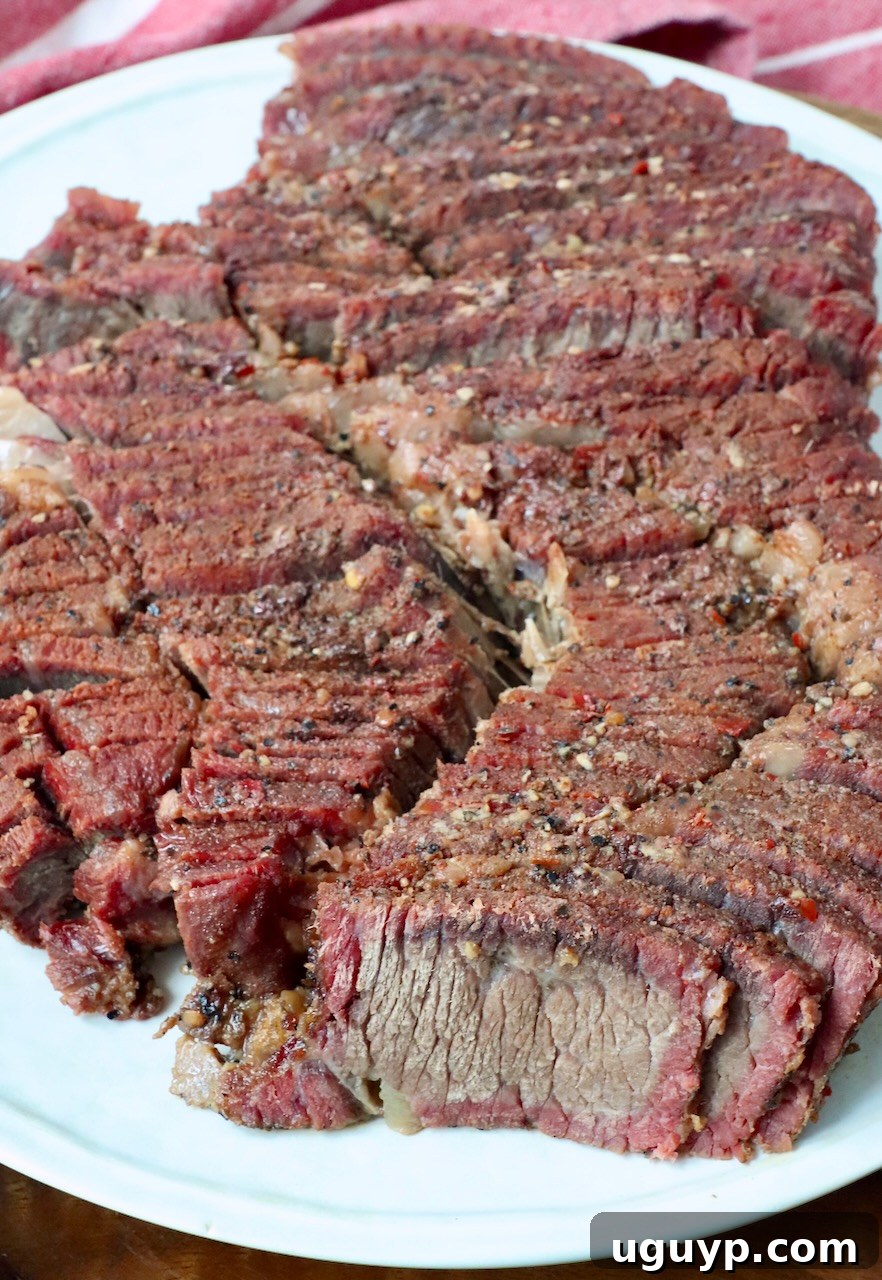 A perfectly smoked chuck roast, beautifully sliced and ready for serving on a plate.