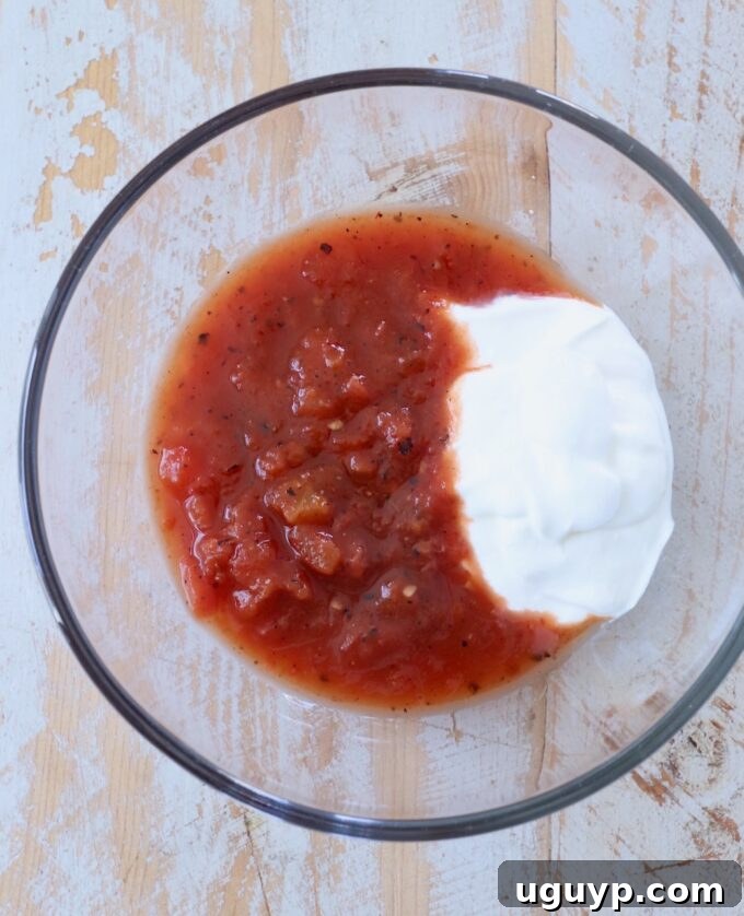 A glass bowl filled with sour cream, ready to be mixed for the taco salad dressing.