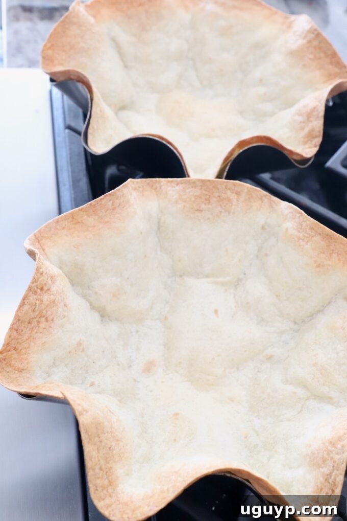 Crispy baked tortilla bowls resting on a wire rack, perfect for serving taco salad.