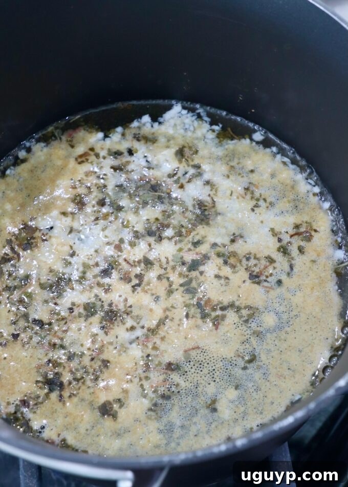 A medium pot on the stove, holding a simmering pickling liquid infused with vibrant spices, indicating the preparation of the escabeche base.