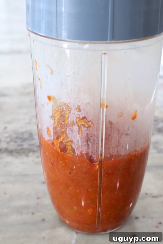 Smooth, creamy tomato sauce being pureed in a blender, ready to be returned to the pan for the next stage of the Paneer Makhani.