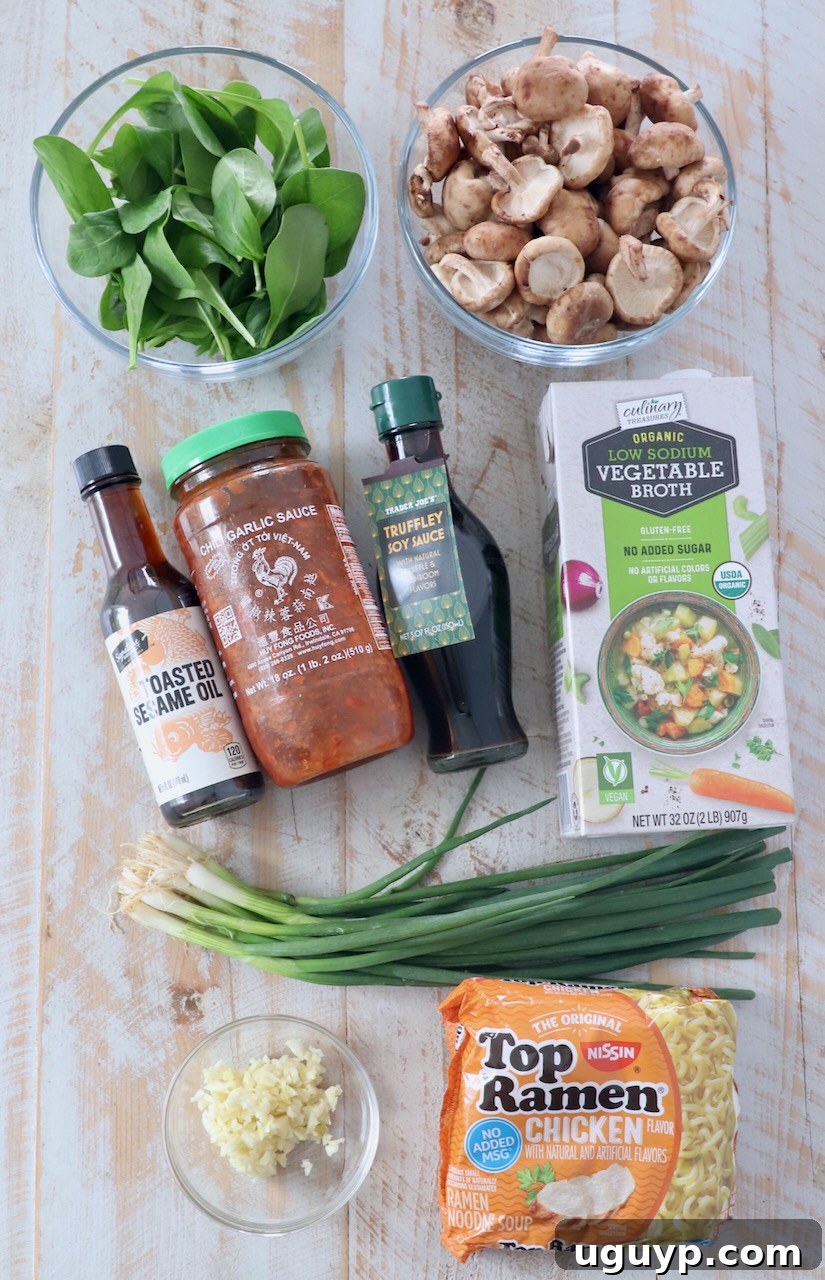 Ingredients for homemade vegetarian ramen laid out on a white wooden board, including shiitake mushrooms, spinach, garlic, soy sauce, and ramen noodles.