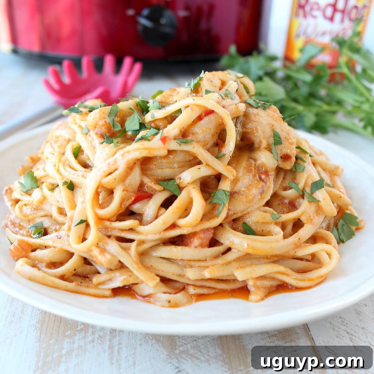 Creamy Crock Pot Buffalo Chicken Alfredo sauce with tender chicken, ready to be served over pasta.
